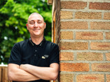 Tenant smiling leaning against a wall 