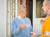 Woman checking I.D of caller at her home